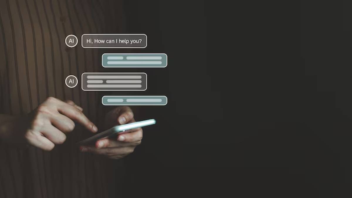 A hand holds a smartphone, displaying an AI chat interface with messages asking how it can help, against a dark background.