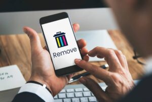 A person holding a smartphone displaying a Remove option with a colorful trash can icon, indicating file deletion.