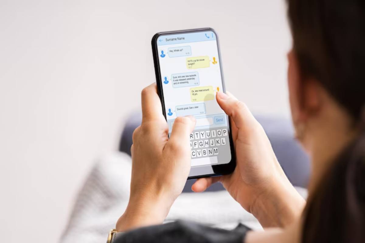 A person texting on a smartphone, discussing plans for a movie night, with messages visible on the screen.