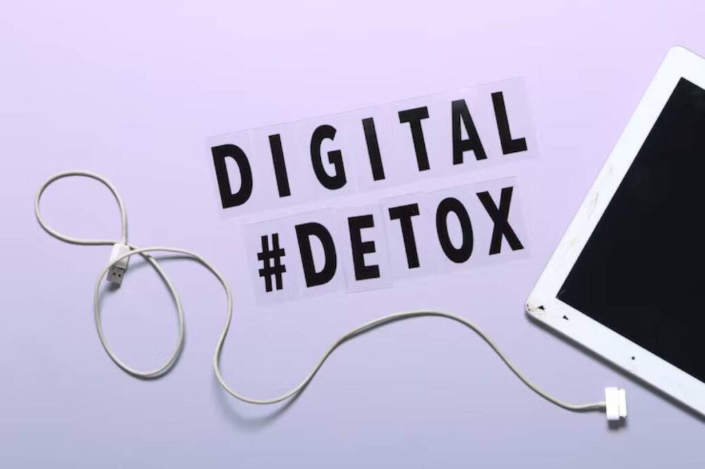 The phrase DIGITAL #DETOX is displayed with a white charging cable and a tablet on a soft purple background.