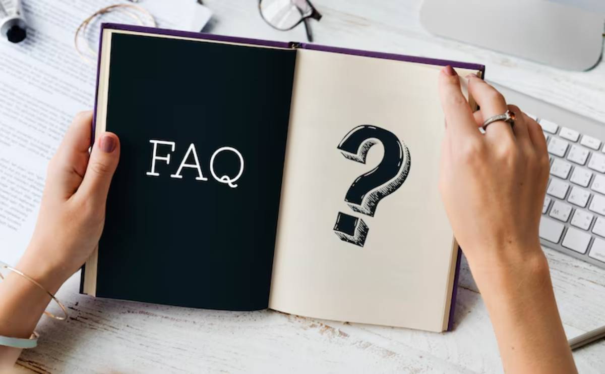 A person holds an open book displaying FAQ on one page and a large question mark on the opposite page, symbolizing inquiries and answers.