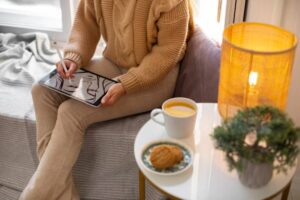 A minimalist workspace featuring a person holding a smartphone or tablet, surrounded by calm, neutral tones — perhaps a plant, a notebook, a cup of tea, and no digital clutter.